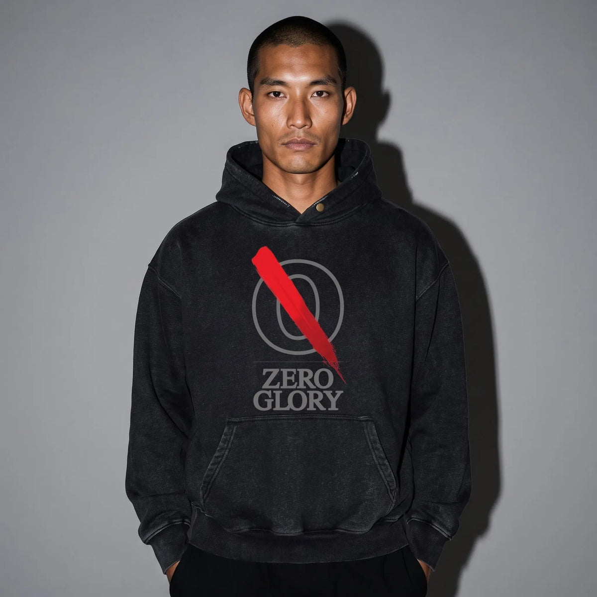 Model wearing the Zero Glory Overcast Heavyweight Oversized Hoodie featuring logo and red accent on a gray background.