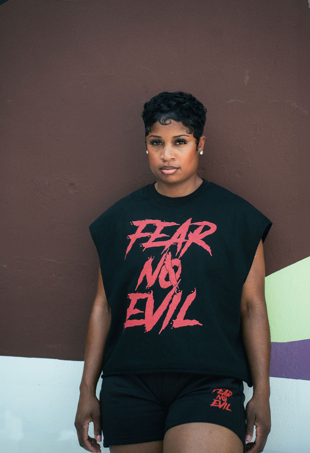 Brand owner wearing a black sleeveless shirt with 'Fear No Evil' in red text against a brown wall.