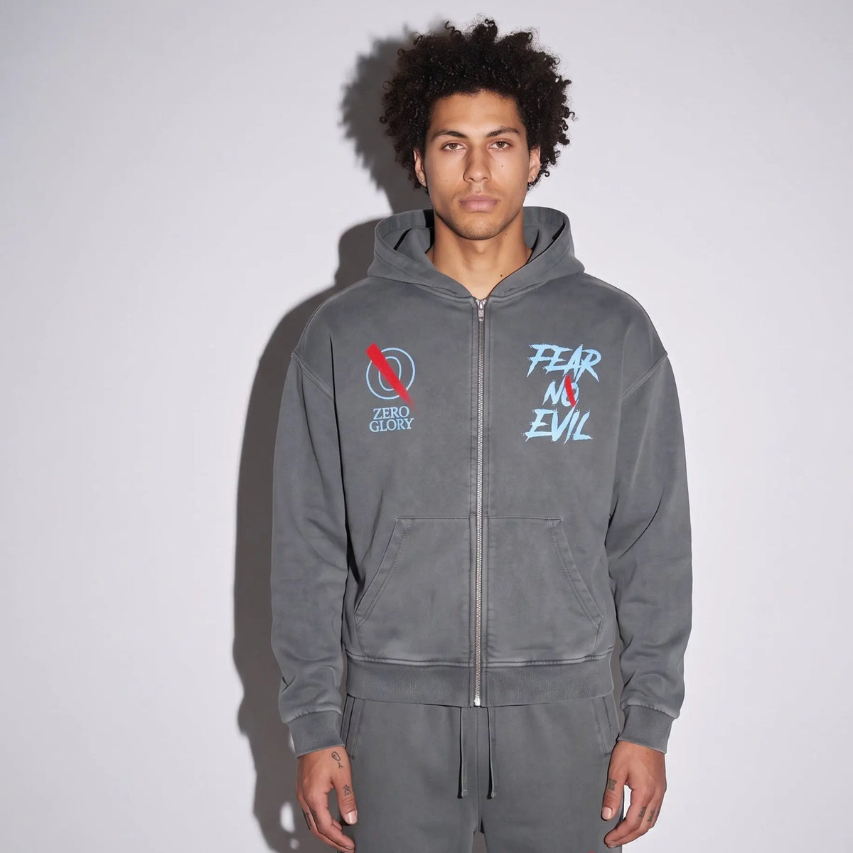 Model wearing Signature Dual Logo Heavyweight Hoodie, showcasing heavyweight cotton hoodie in washed blue-gray color.