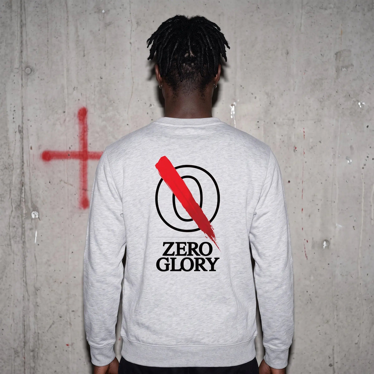 Back view of a man wearing a Zero Glory heavyweight crewneck sweatshirt with a bold logo and graphic design.