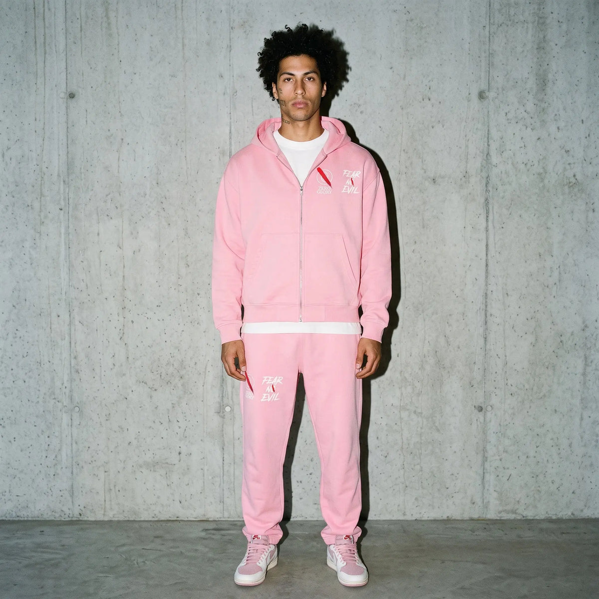 Model wearing Zero Glory Pink Warrior Sweatpants, showcasing streetwear style for comfort and breast cancer awareness.