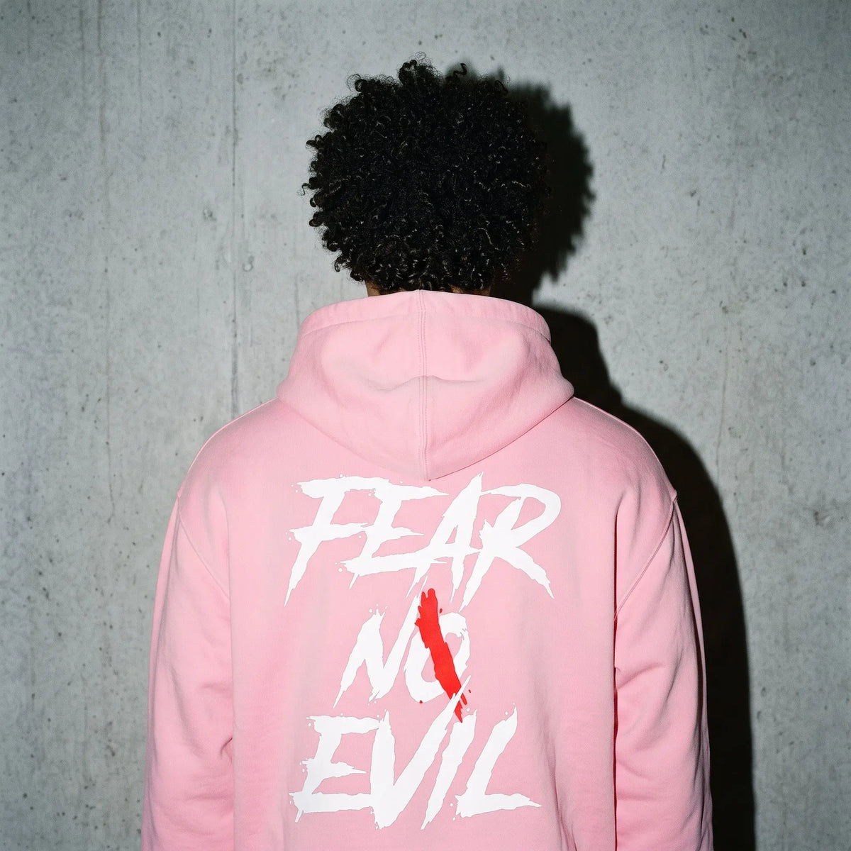 Back view of a person wearing a Zero Glory Pink Warrior Zip Hoodie with 'FEAR NO EVIL' graphic, supporting Breast Cancer Awareness Zip Hoodie.
