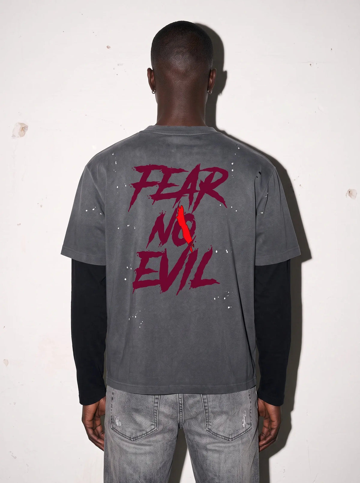 Back view of a person wearing a distressed cotton long sleeve shirt with the text 'FEAR NO EVIL' printed in bold.